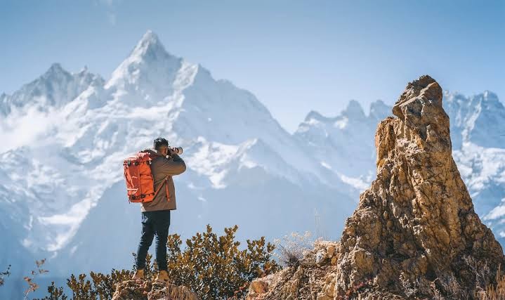 Photographer with a Summit Creative backpack in the mountains