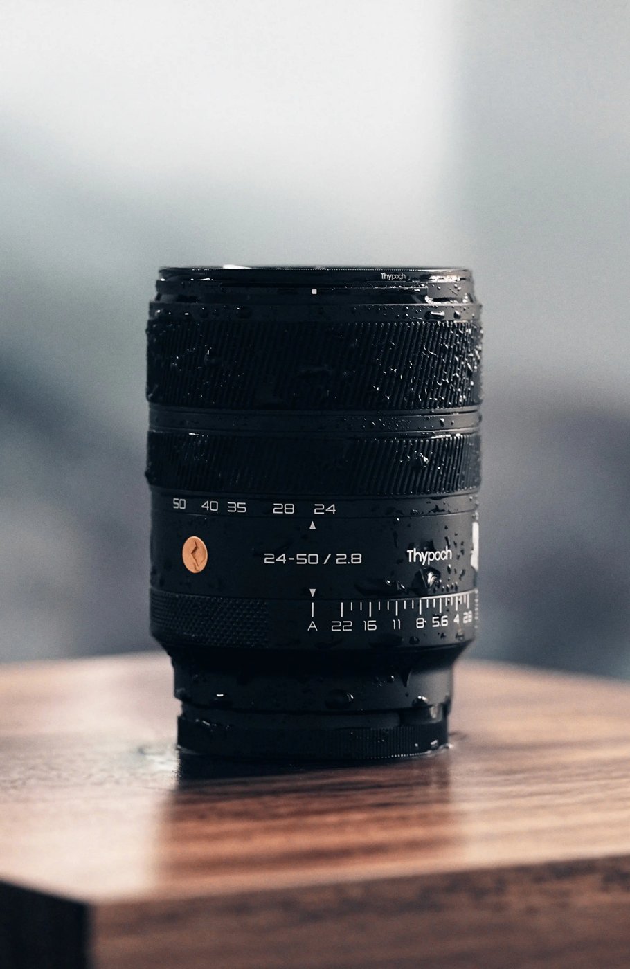 Thypoch 24-50mm f/2.8 lens on a wooden table